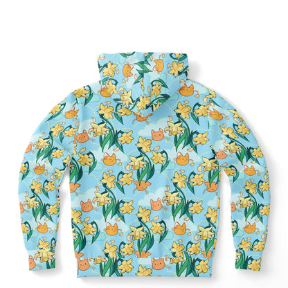 A flat lying hoodie.  The hoodie's pattern features cute cat faces and daffodils on a blue background. The pocket and lining of the hood are orange