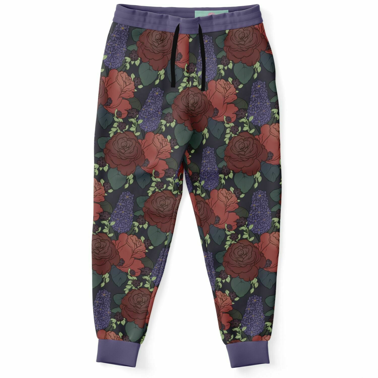 The front of a pair of joggers lying flat., it has a black, flat drawstring. The base colour is dark grey, and it has a repeating pattern. The pattern features two big red roses with dark green leaves, a large purple hyacinth, surrounded by small black petunias with bright green leaves. The waistband and cuffs are purple.