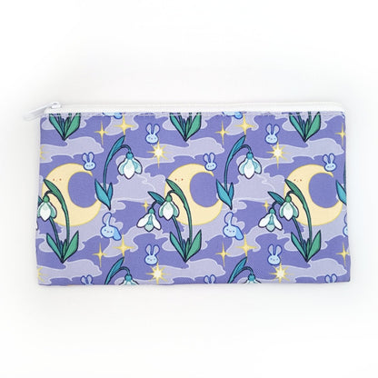 A pencil case. It is purple with a smoky background. It features stars, the moon, snowdrops, and cute bunny heads floating around.