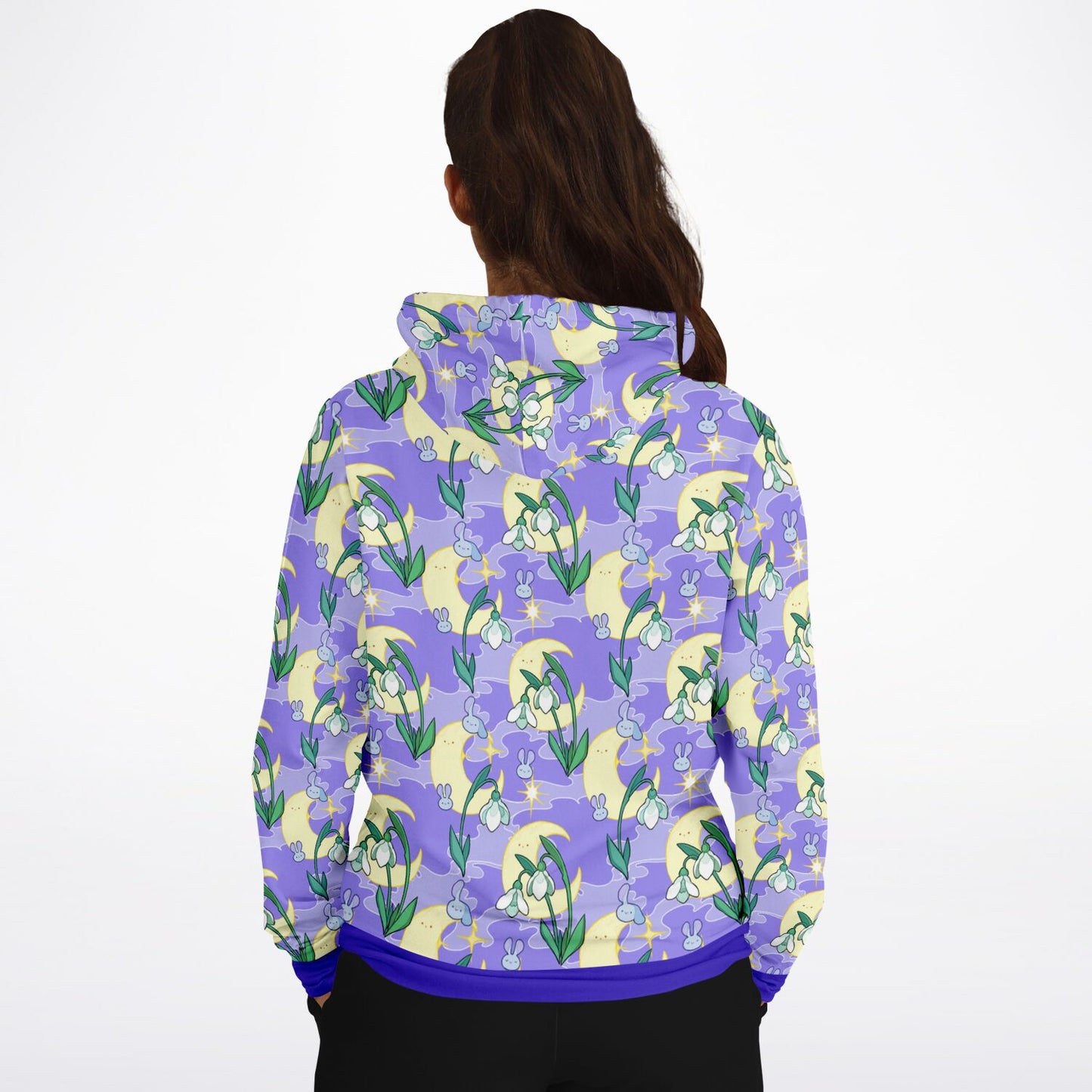 A model wearing a hoodie. The hoodie's pattern features bunnies, snowbells, and the moon. It has a purple smokey background.