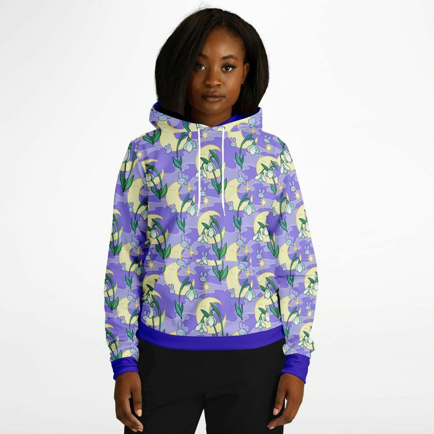 A model wearing a hoodie. The hoodie's pattern features bunnies, snowbells, and the moon. It has a purple smokey background.