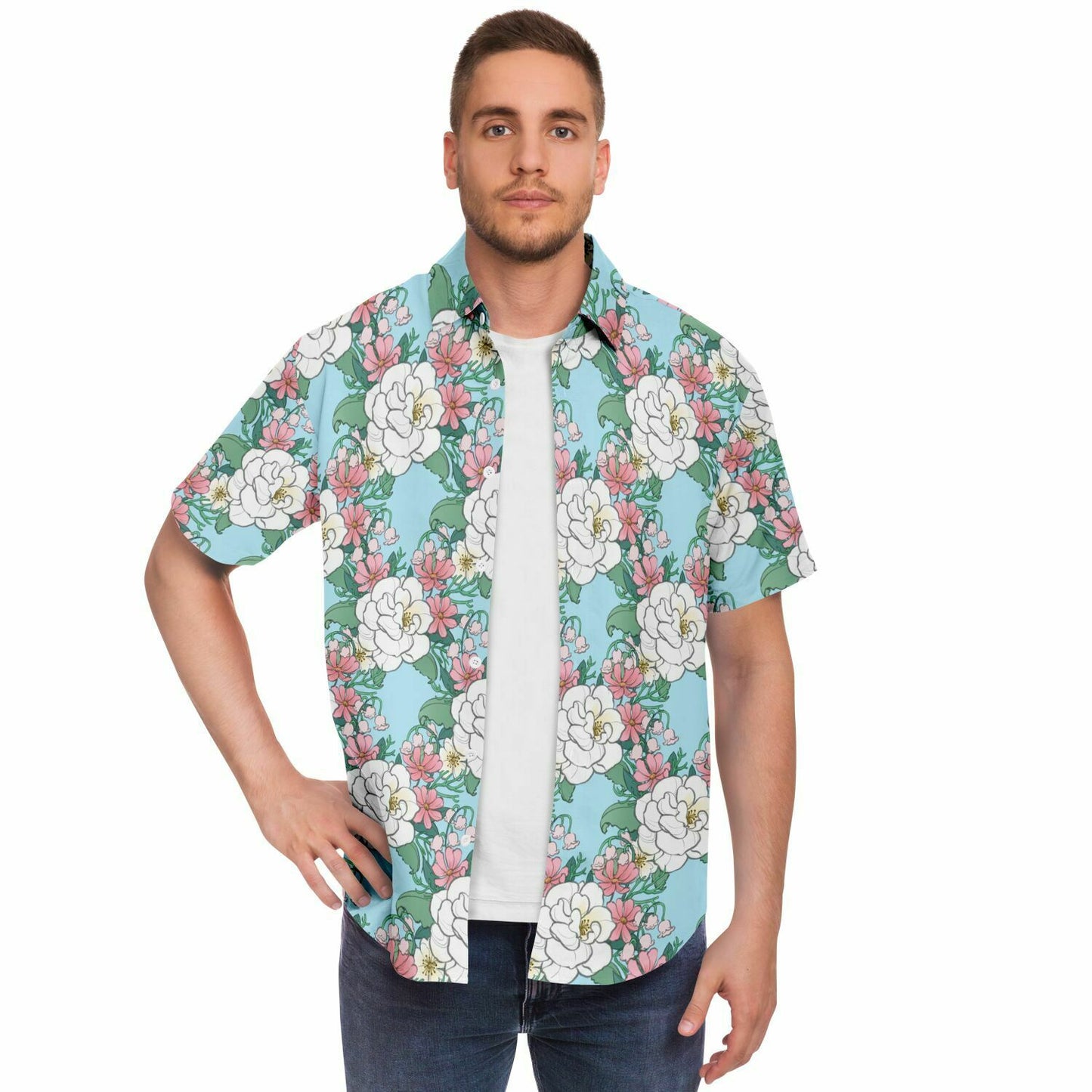 A model wearing a button down. The button down's pattern features white wild roses, pink cosmos, and lillies of the valley on a light blue background. it has a pink hem and cuffs.