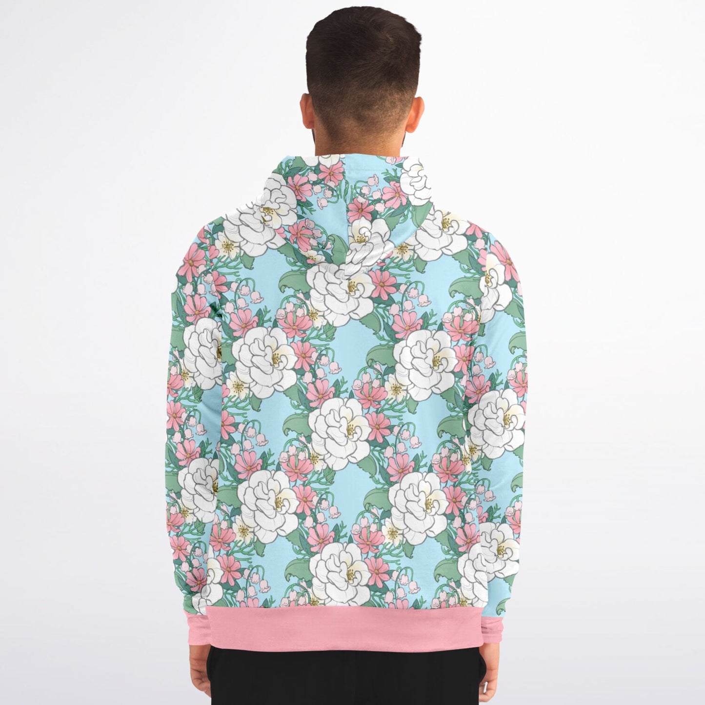 A model wearing a hoodie. The hoodie's pattern features white wild roses, pink cosmos, and lillies of the valley on a light blue background. it has a pink hem and cuffs.